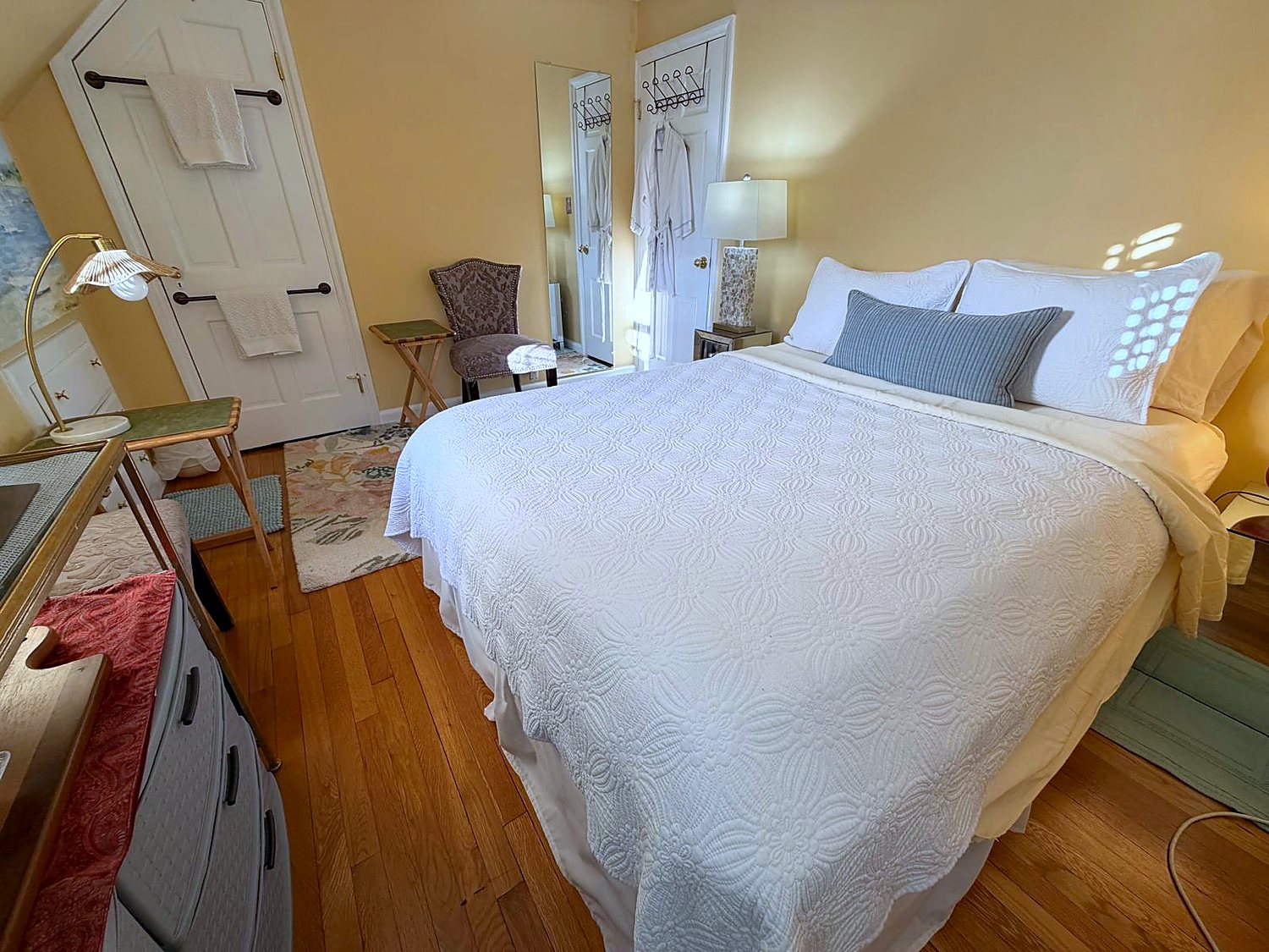 The English Garden Room at Wellesley Boutique Inn, with a queen bed and hardwood floors