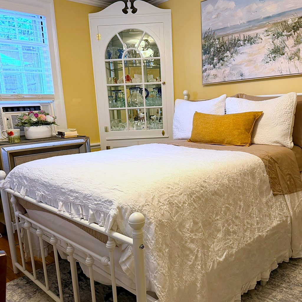 The ground-floor Vacation Rental room at Wellesley Boutique Inn, with a full-size bed and corner display cabinet